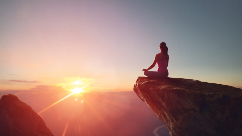 朝日とヨガで瞑想をする女性の姿 立川発イタリア溶岩ホットヨガピラティス専門スタジオontheshore