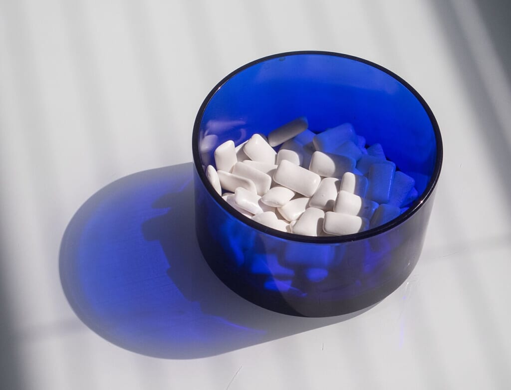 Xylitol chewing gum in a blue bowl | オンザショア立川店 立川駅徒歩1分年中無休の溶岩ホットヨガスタジオ 青いボウルに入れられたキシリトールを含むチューインガムの写真 立川駅徒歩1分年中無休の溶岩ホットヨガスタジオ