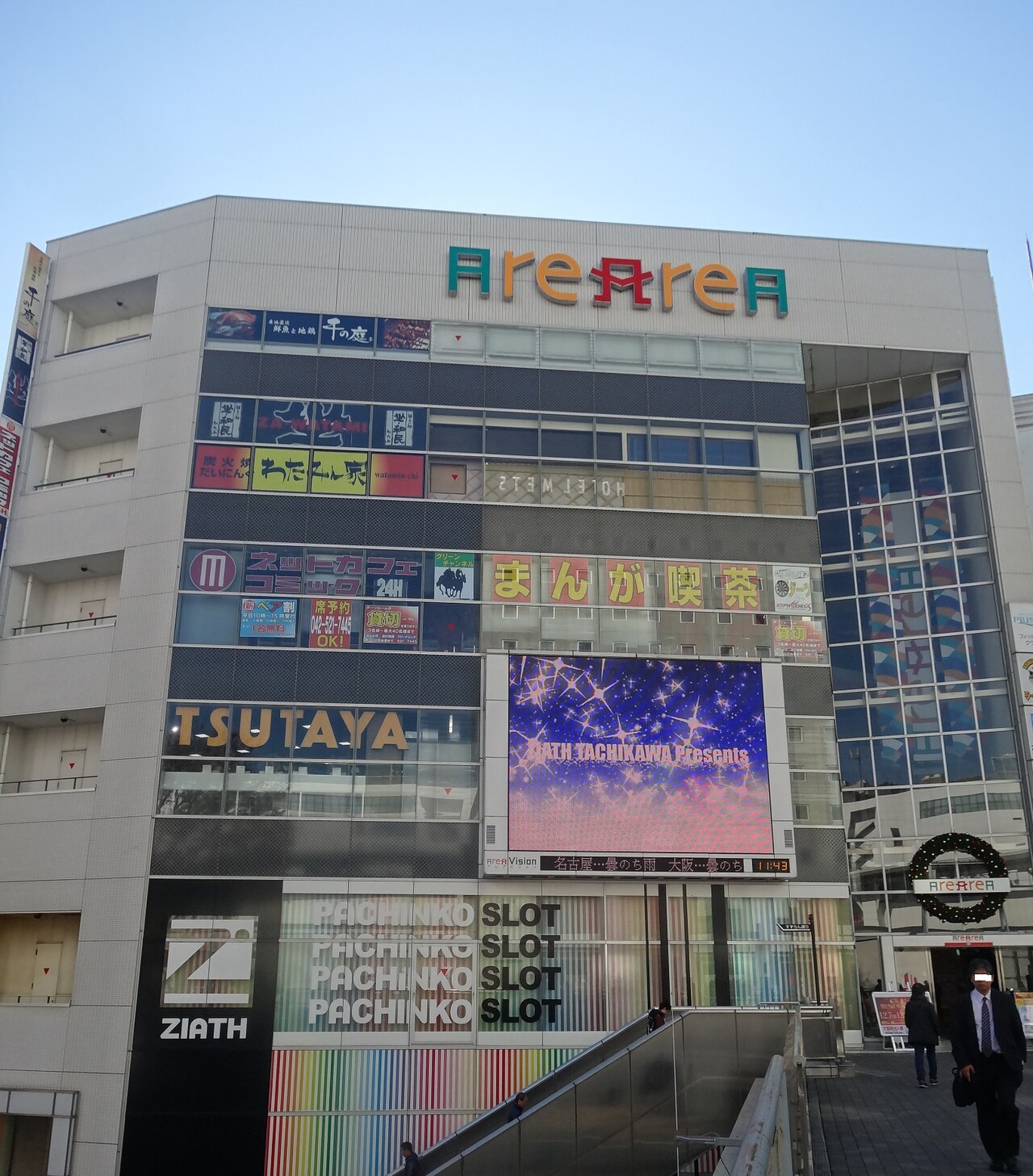 Alearea at Tachikawa Station's South Exit, with a big screen on its wall and the deck reaching the building.