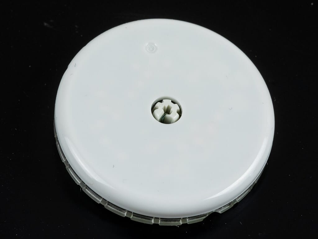 Abbott Freestyle Libre 2 glucose sensor1157 | オンザショア立川店 立川駅徒歩1分年中無休の溶岩ホットヨガスタジオ 黒い背景の上に置かれた白い円盤の形をした持続血糖測定用のセンサー 立川駅徒歩1分年中無休の溶岩ホットヨガスタジオ