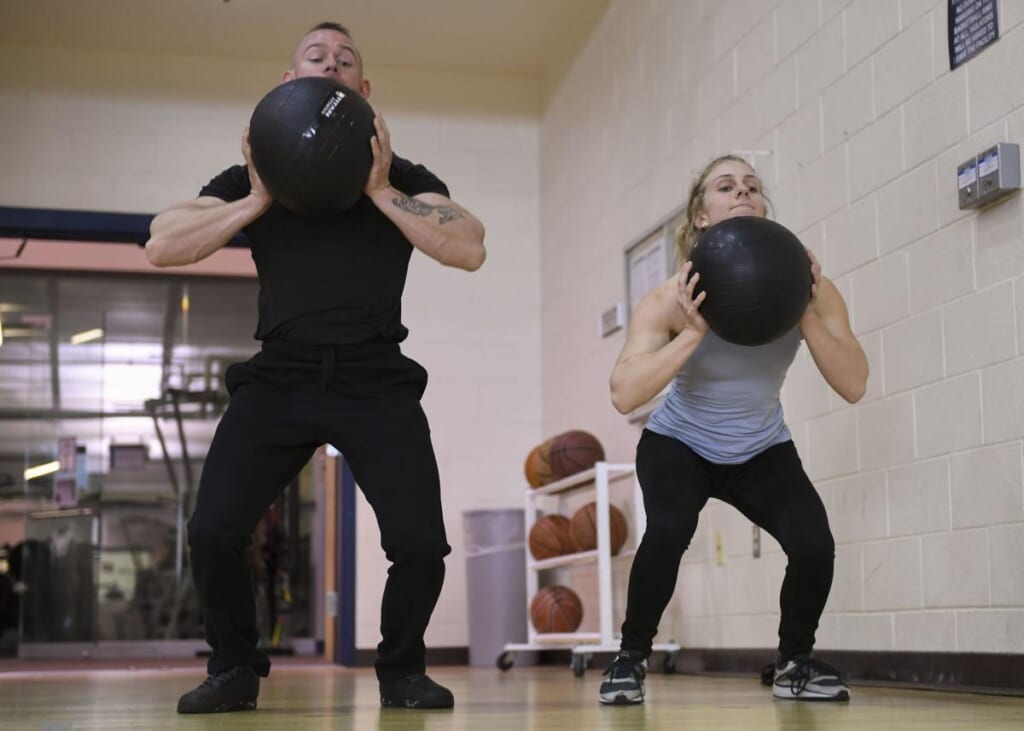 Ballistic training medicine ball throw | オンザショア立川店 立川駅徒歩1分年中無休の溶岩ホットヨガスタジオ 重いメディシンボールを投げる動作に取り組むトレーニング中の人物 立川駅徒歩1分年中無休の溶岩ホットヨガスタジオ