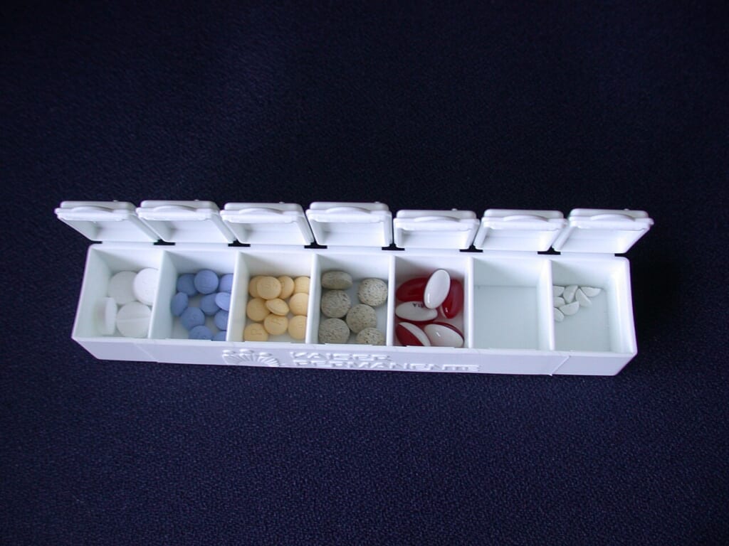 Pill box with pills | オンザショア立川店 立川駅徒歩1分年中無休の溶岩ホットヨガスタジオ 複数の種類の薬が中に入っている服薬用のピルケースを写した写真 立川駅徒歩1分年中無休の溶岩ホットヨガスタジオ