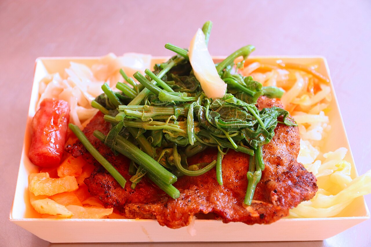 ご飯と野菜、ソーセージや肉のおかずが一つの容器に詰められた弁当。