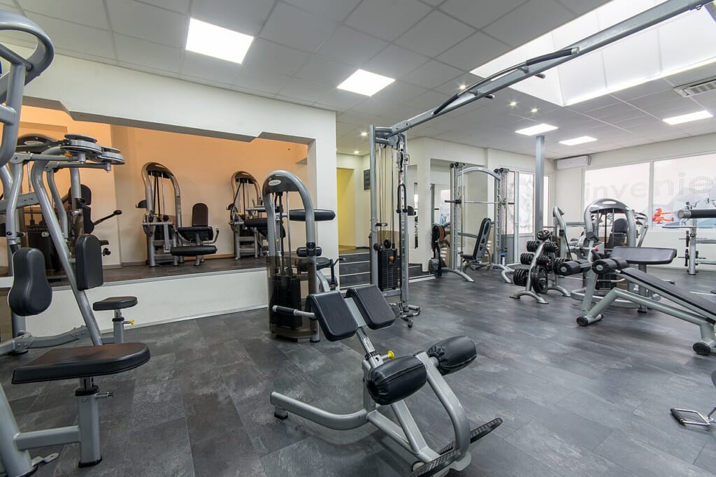 Interior of new modern gym with equipment | オンザショア立川店 立川駅徒歩1分年中無休の溶岩ホットヨガスタジオ さまざまな運動用の器具が設置された近代的なジムの室内を写した写真 立川駅徒歩1分年中無休の溶岩ホットヨガスタジオ