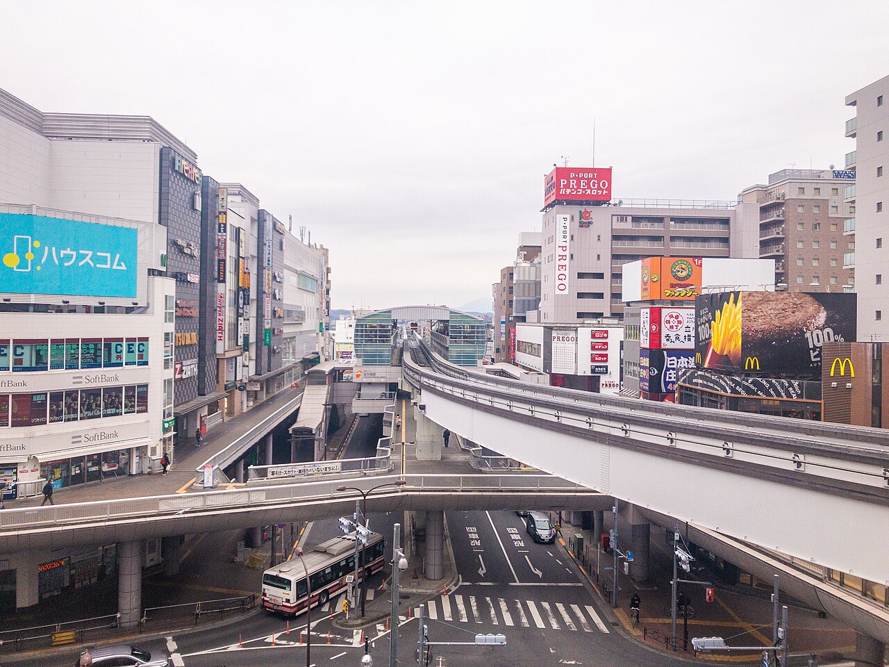 Tachikawa-Minami Station seen from the north, the guideway curving gently right above a wide avenue