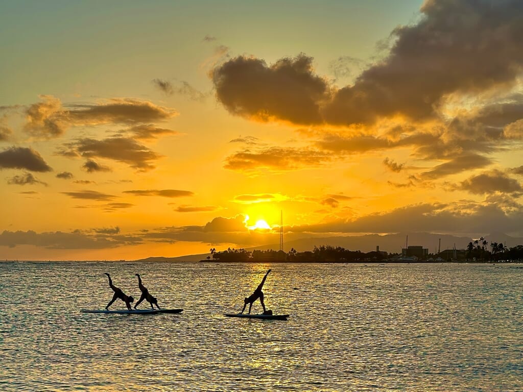 Surf Yoga Sunset Flickr stevehfung | オンザショア立川店 立川駅徒歩1分年中無休の溶岩ホットヨガスタジオ 夕焼けの海でボードの上に立ってヨガをする人たち 立川駅徒歩1分年中無休の溶岩ホットヨガスタジオ