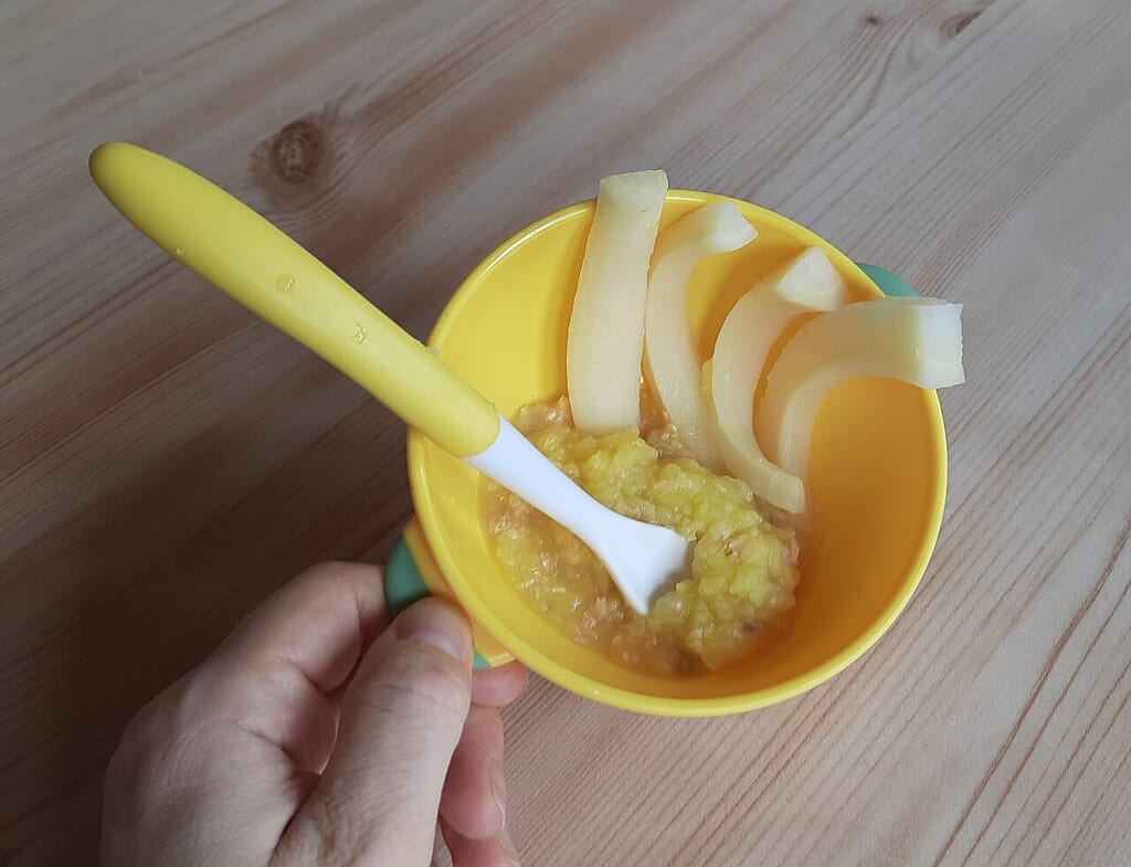 Starting solids homemade baby food in a bowl | オンザショア立川店 立川駅徒歩1分年中無休の溶岩ホットヨガスタジオ ジャガイモのピューレにサケと柔らかく煮た野菜を合わせスプーンを添えた器の離乳食 立川駅徒歩1分年中無休の溶岩ホットヨガスタジオ