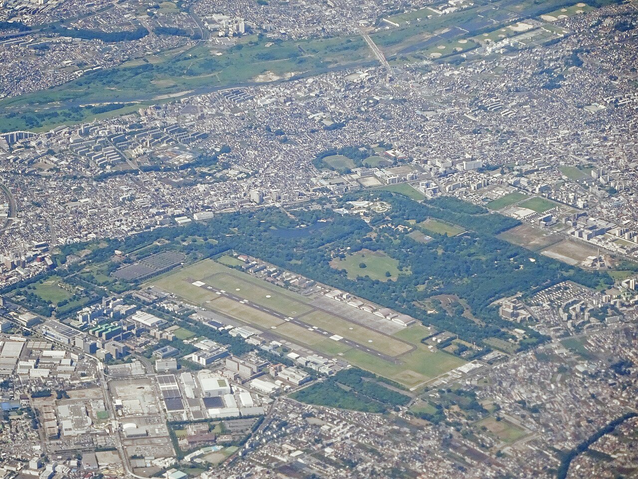 Tachikawa Airfield seen from the air to the north, with the green former base land beyond (2023)