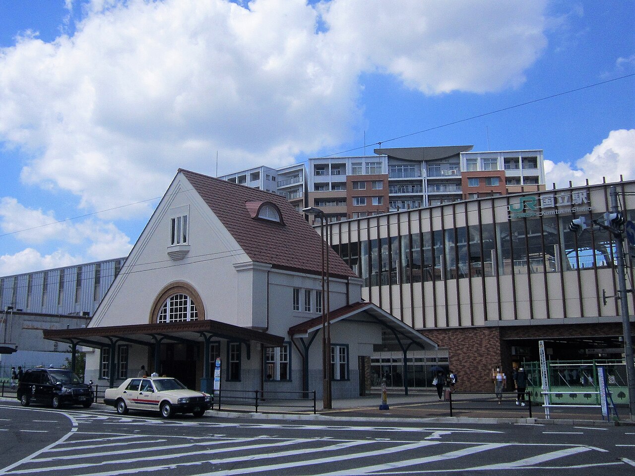 The Former Kunitachi Station Building, rebuilt in 2020, with its red triangular roof, white walls and arched windows.