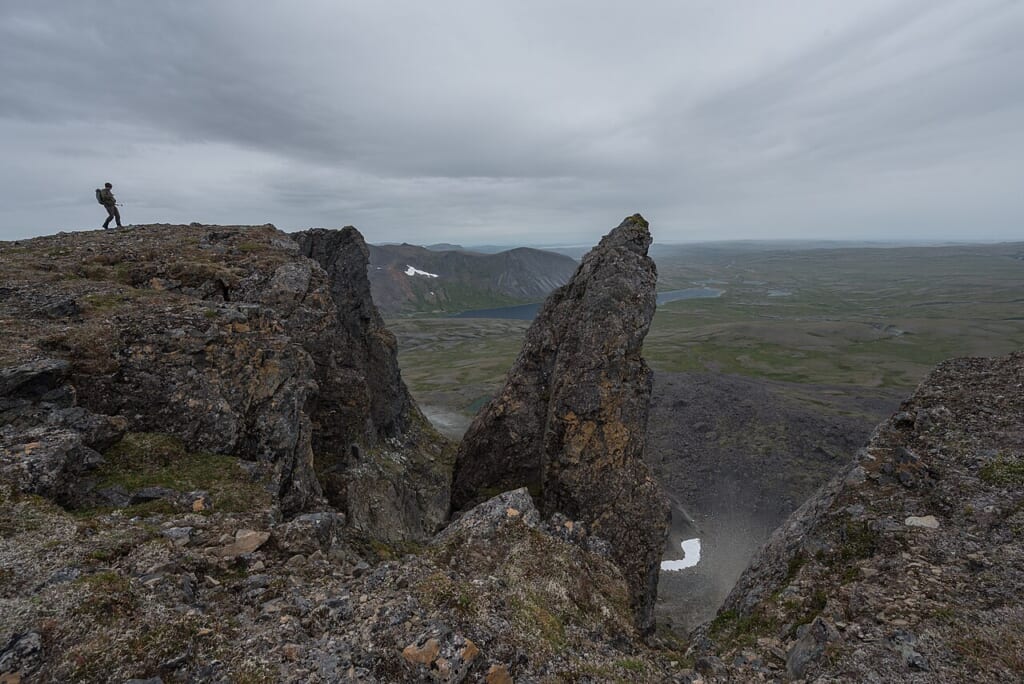 A hiker stands on a mountain summit Katmai Preserve NPS Photo Russ Taylor 44430194821 | オンザショア立川店 立川駅徒歩1分年中無休の溶岩ホットヨガスタジオ 山の頂上に立っているハイカーの姿を山頂の風景とともに写した写真 立川駅徒歩1分年中無休の溶岩ホットヨガスタジオ