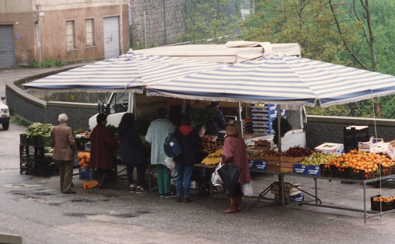 市場の売り場に並べられた果物と野菜を写した、青果を販売する露店の写真。