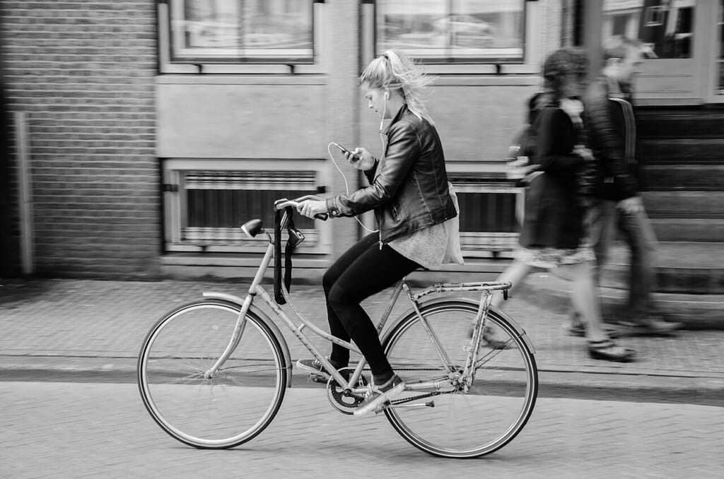 自転車に乗って移動する人の姿を写したアムステルダムでのサイクリングの写真 立川駅徒歩1分年中無休の溶岩ホットヨガスタジオ