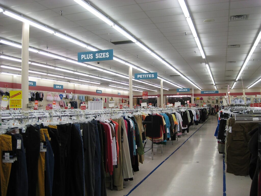 衣料品の売り場に並ぶ服のハンガーラック 立川駅徒歩1分年中無休の溶岩ホットヨガスタジオ