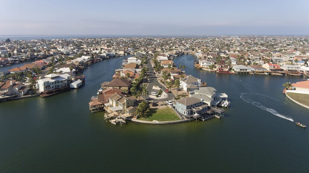 An aerial photo of a residential neighborhood on Padre Island | オンザショア立川店 立川駅徒歩1分年中無休の溶岩ホットヨガスタジオ 住宅がまとまって並ぶ住宅地を上空から広い範囲にわたって捉えた写真 立川駅徒歩1分年中無休の溶岩ホットヨガスタジオ