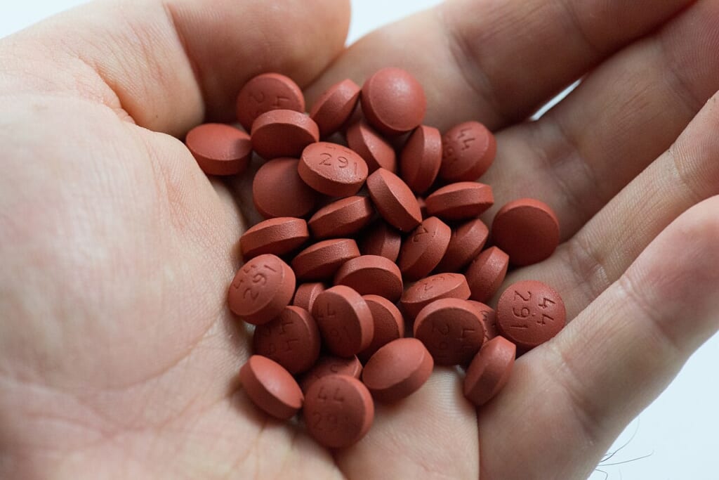 Ibuprofen tablets in palm of hand | オンザショア立川店 立川駅徒歩1分年中無休の溶岩ホットヨガスタジオ 開いた手のひらの上に複数の錠剤が載っている様子を写した手元の写真 立川駅徒歩1分年中無休の溶岩ホットヨガスタジオ