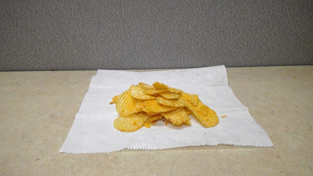 A pile of All Dressed potato chips on a paper towel | オンザショア立川店 立川駅徒歩1分年中無休の溶岩ホットヨガスタジオ ペーパータオルの上に重なり合って山積みにされたポテトチップス 立川駅徒歩1分年中無休の溶岩ホットヨガスタジオ