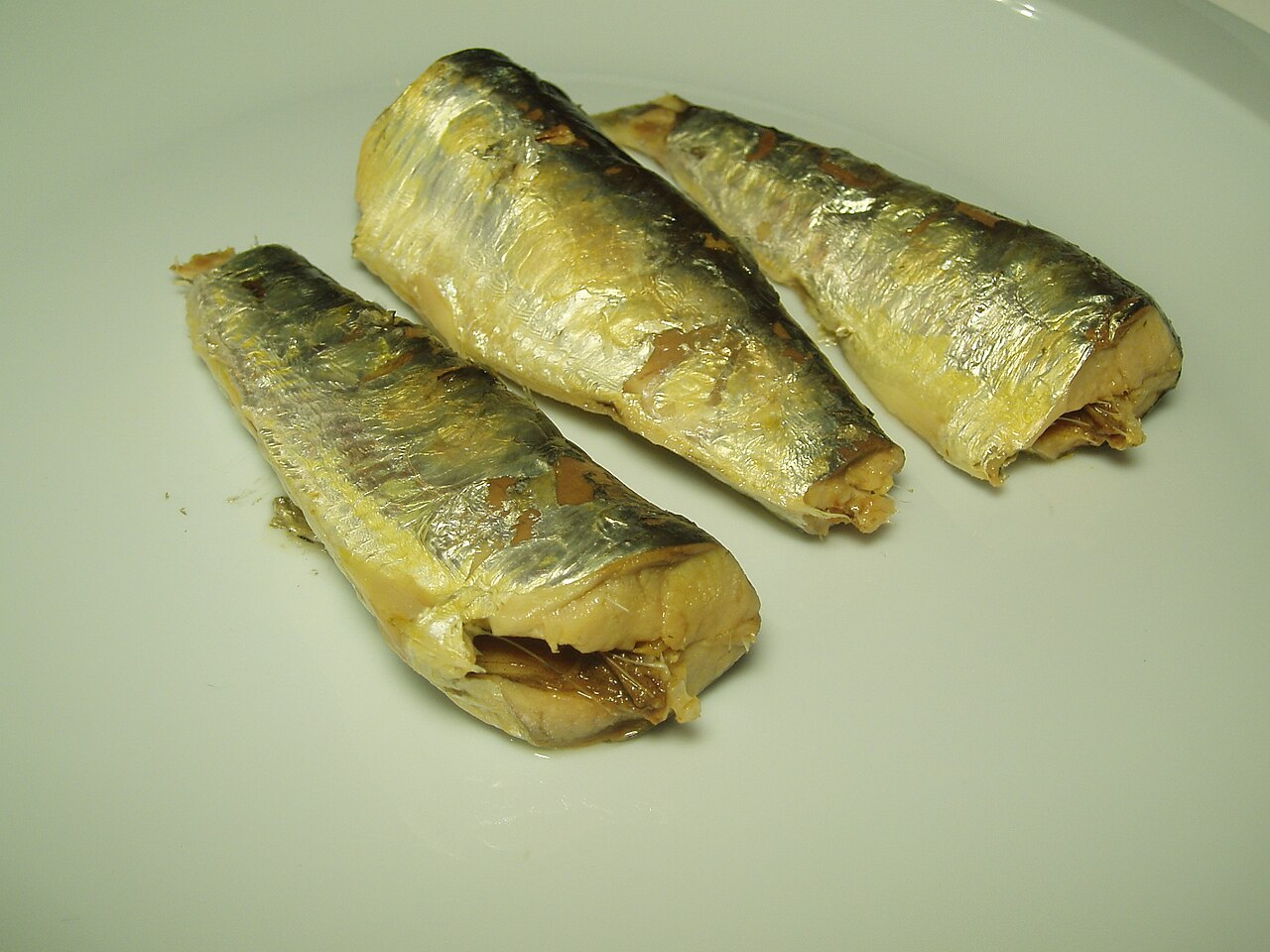 皿に盛り付けられた塩水漬けの缶詰のイワシ。魚を主な食材とする一皿。