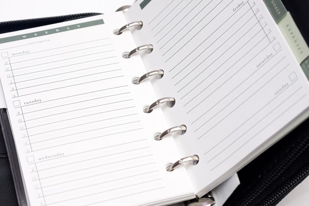 Personal organizer with metallic ring binder | オンザショア立川店 立川駅徒歩1分年中無休の溶岩ホットヨガスタジオ 曜日ごとの欄がある罫線入りの用紙を金属のリングでとじたシステム手帳 立川駅徒歩1分年中無休の溶岩ホットヨガスタジオ