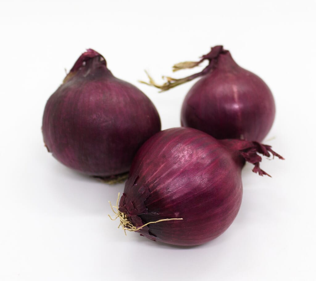 Three whole red onions | オンザショア立川店 立川駅徒歩1分年中無休の溶岩ホットヨガスタジオ 丸ごとの赤玉ねぎ三つを写した写真切られていない玉ねぎの外皮が見える 立川駅徒歩1分年中無休の溶岩ホットヨガスタジオ