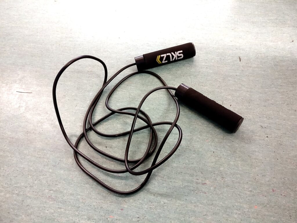 Jump rope in ground | オンザショア立川店 立川駅徒歩1分年中無休の溶岩ホットヨガスタジオ 地面に置かれた縄跳び用の縄とその周囲の地面が写っている写真 立川駅徒歩1分年中無休の溶岩ホットヨガスタジオ