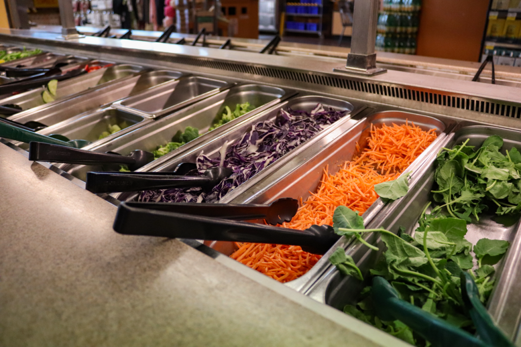 Grocery store salad bar | オンザショア立川店 立川駅徒歩1分年中無休の溶岩ホットヨガスタジオ 食料品店のサラダバーに並べられたチーズや野菜などのさまざまな食材 立川駅徒歩1分年中無休の溶岩ホットヨガスタジオ