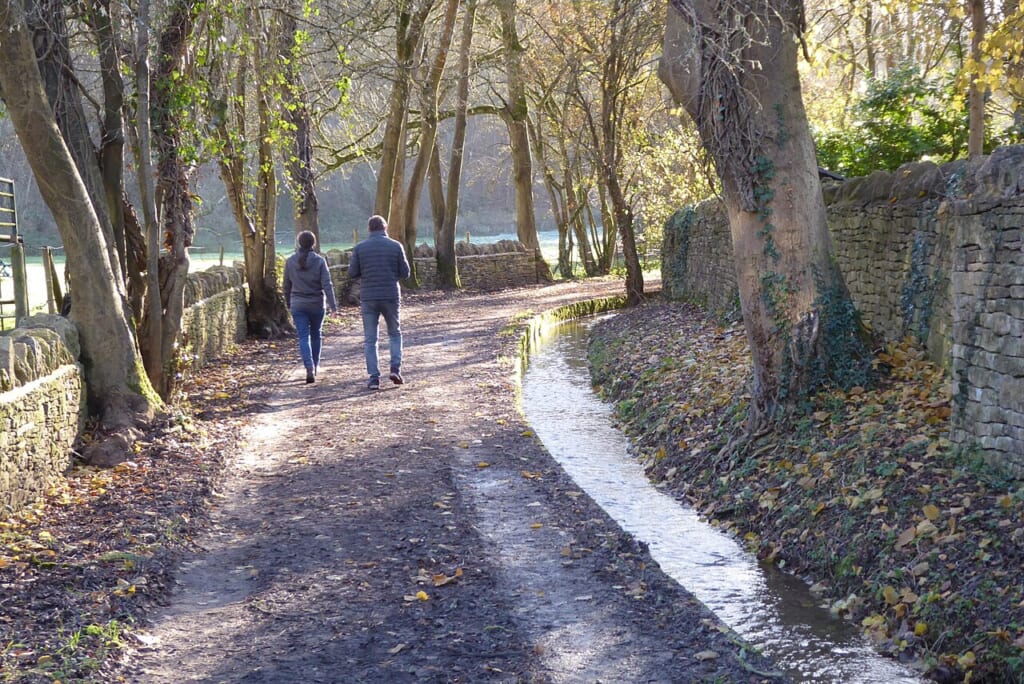 A couple walking on a bridleway geographorguk 7661036 | オンザショア立川店 立川駅徒歩1分年中無休の溶岩ホットヨガスタジオ 屋外の道を二人で歩く様子を写した一緒に歩く場面が題材の横長の写真 立川駅徒歩1分年中無休の溶岩ホットヨガスタジオ