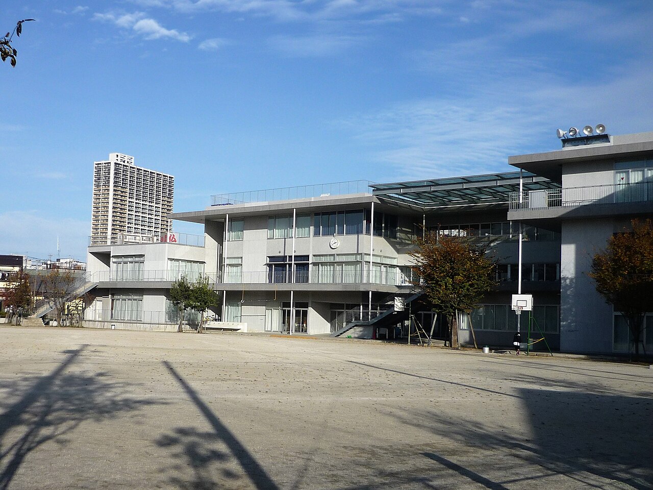The schoolyard and rebuilt building of Tachikawa Daiichi Elementary School, with a residential tower beyond