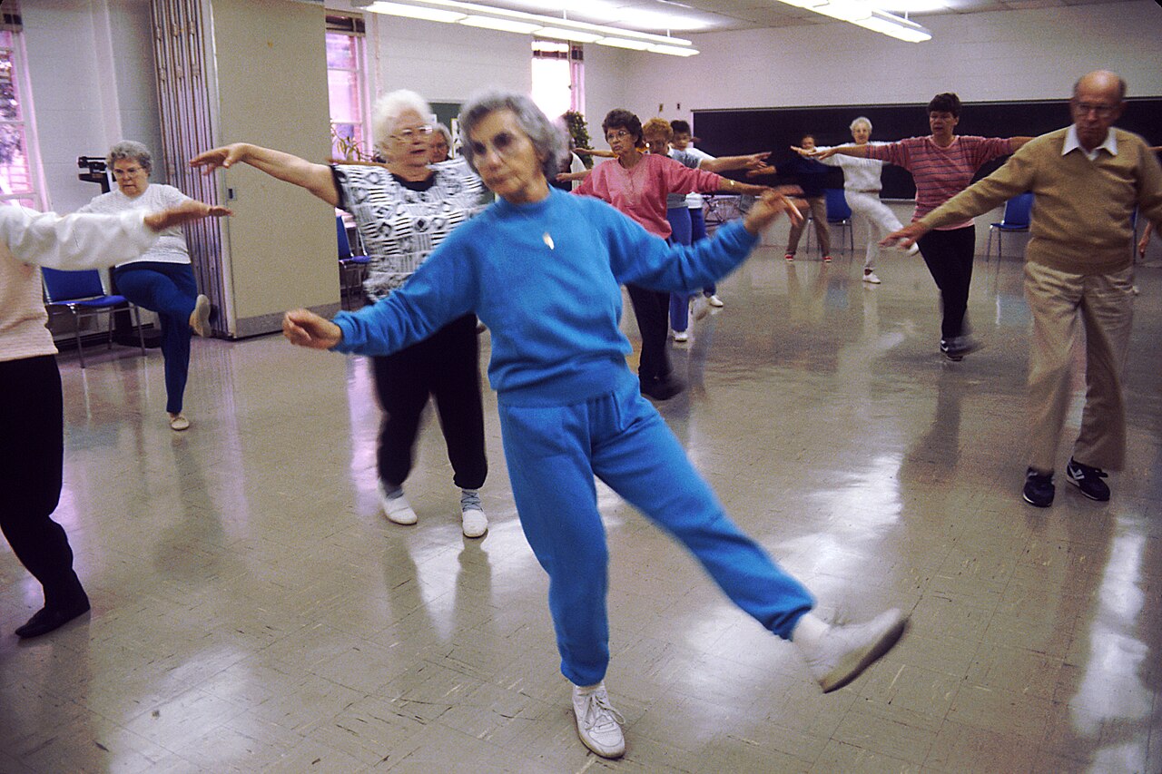Older men and women take part in a group aerobics class.