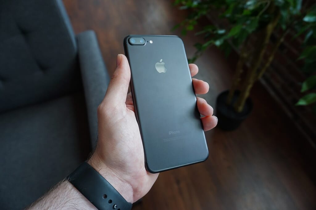 Black smartphone in hand Unsplash | オンザショア立川店 立川駅徒歩1分年中無休の溶岩ホットヨガスタジオ 手に持った黒いスマートフォンの本体と画面が写っている横長の写真 立川駅徒歩1分年中無休の溶岩ホットヨガスタジオ