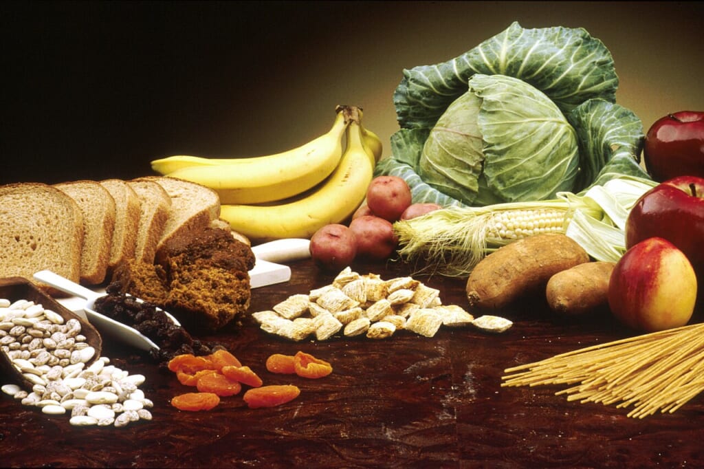 豆茶色いパンバナナキャベツトウモロコシりんごなどが並ぶ木のテーブル 立川駅徒歩1分年中無休の溶岩ホットヨガスタジオ