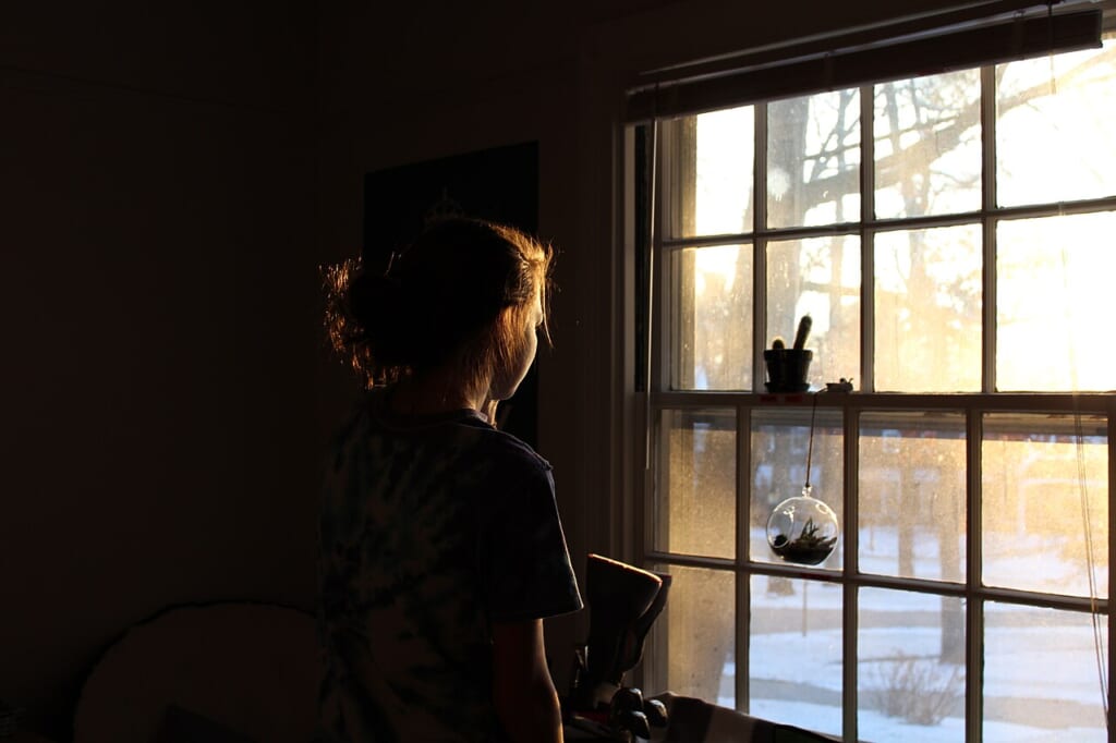 A woman looking out the window Unsplash | オンザショア立川店 立川駅徒歩1分年中無休の溶岩ホットヨガスタジオ 窓の外へ視線を向けている女性を写した室内の窓辺の横長の写真 立川駅徒歩1分年中無休の溶岩ホットヨガスタジオ