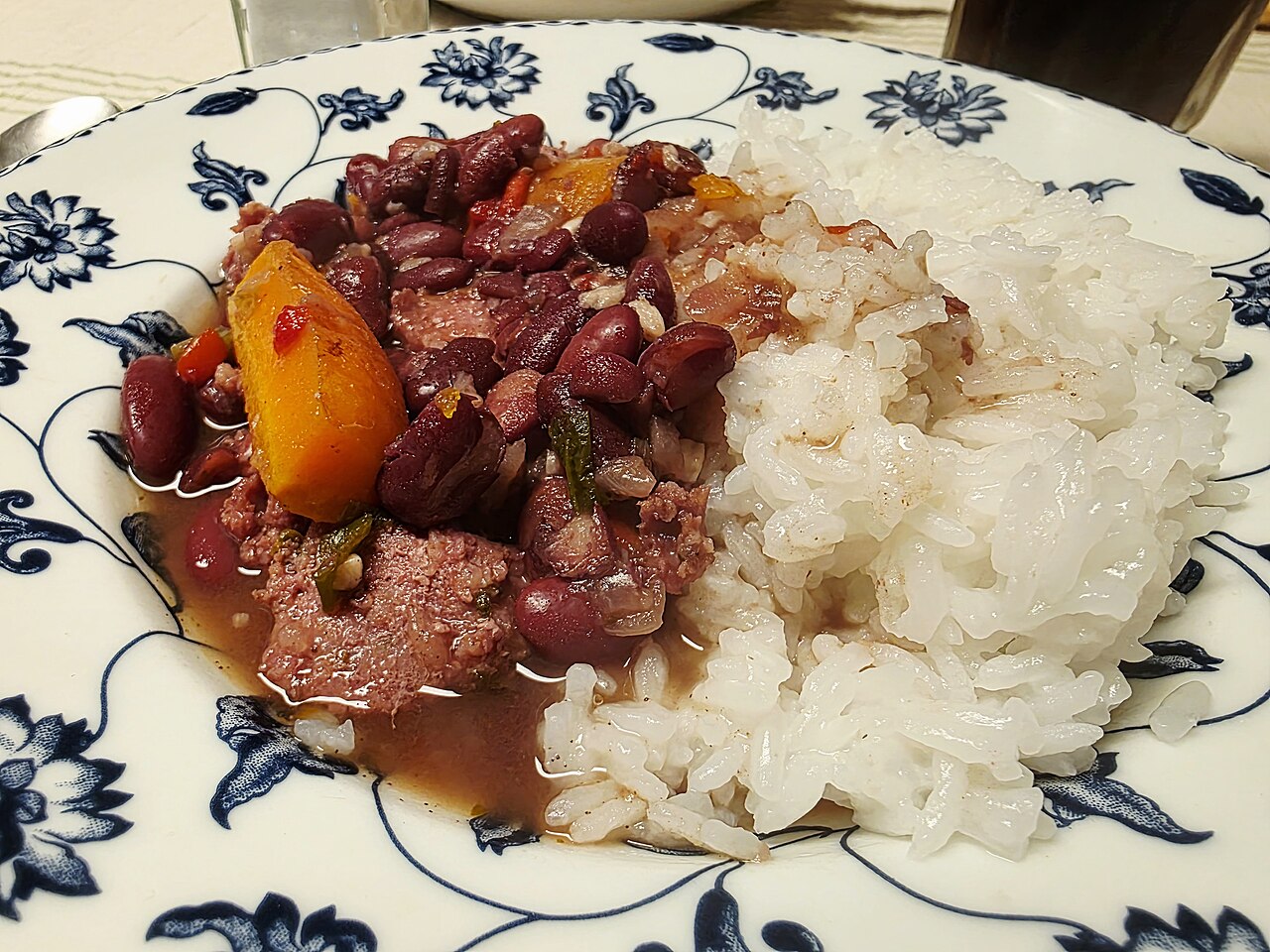 白いご飯を添えた、赤いインゲン豆と燻製ソーセージの手作りの煮込み（アルゼンチン料理）