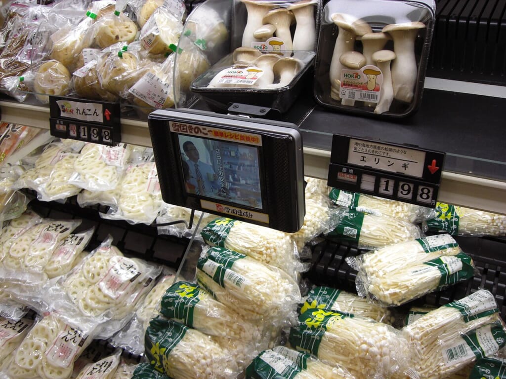 Screen on the supermarket shelf 2654814813 | オンザショア立川店 立川駅徒歩1分年中無休の溶岩ホットヨガスタジオ スーパーの棚に並ぶ袋入りのきのこやれんこんと値札棚に付いた小さな画面 立川駅徒歩1分年中無休の溶岩ホットヨガスタジオ