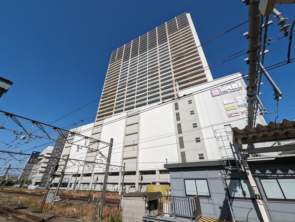 立川タクロス | オンザショア立川店 立川駅徒歩1分年中無休の溶岩ホットヨガスタジオ 立川駅のホームの先に立つ立川タクロス32階の住まいの塔が晴れた秋の空へまっすぐ伸びる 立川駅徒歩1分年中無休の溶岩ホットヨガスタジオ