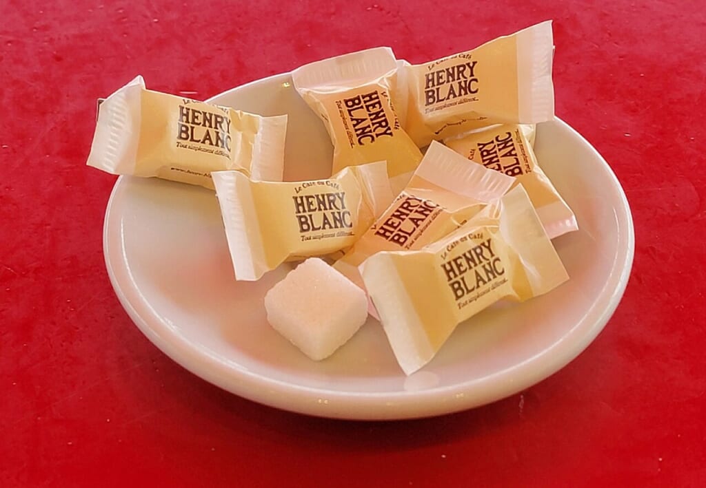 Individually wrapped sugar cubes | オンザショア立川店 立川駅徒歩1分年中無休の溶岩ホットヨガスタジオ 一つずつ個別に包装された角砂糖が写っている砂糖の小分け包装の写真 立川駅徒歩1分年中無休の溶岩ホットヨガスタジオ