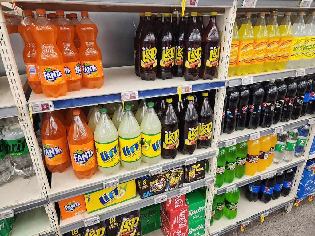 New World fizzy drinks | オンザショア立川店 立川駅徒歩1分年中無休の溶岩ホットヨガスタジオ スーパーマーケットの炭酸飲料売り場にさまざまな飲料が並んでいる様子 立川駅徒歩1分年中無休の溶岩ホットヨガスタジオ