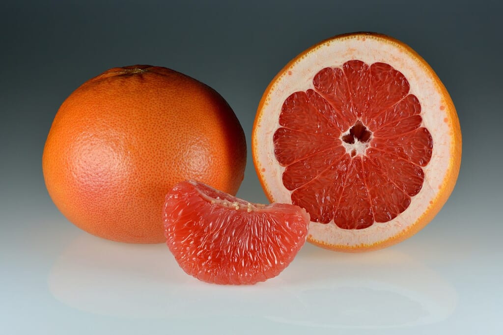 Grapefruits wholehalvedsegments | オンザショア立川店 立川駅徒歩1分年中無休の溶岩ホットヨガスタジオ 丸ごとのもの半分に切ったもの皮をむいた一房が並ぶ赤い果肉のグレープフルーツ 立川駅徒歩1分年中無休の溶岩ホットヨガスタジオ