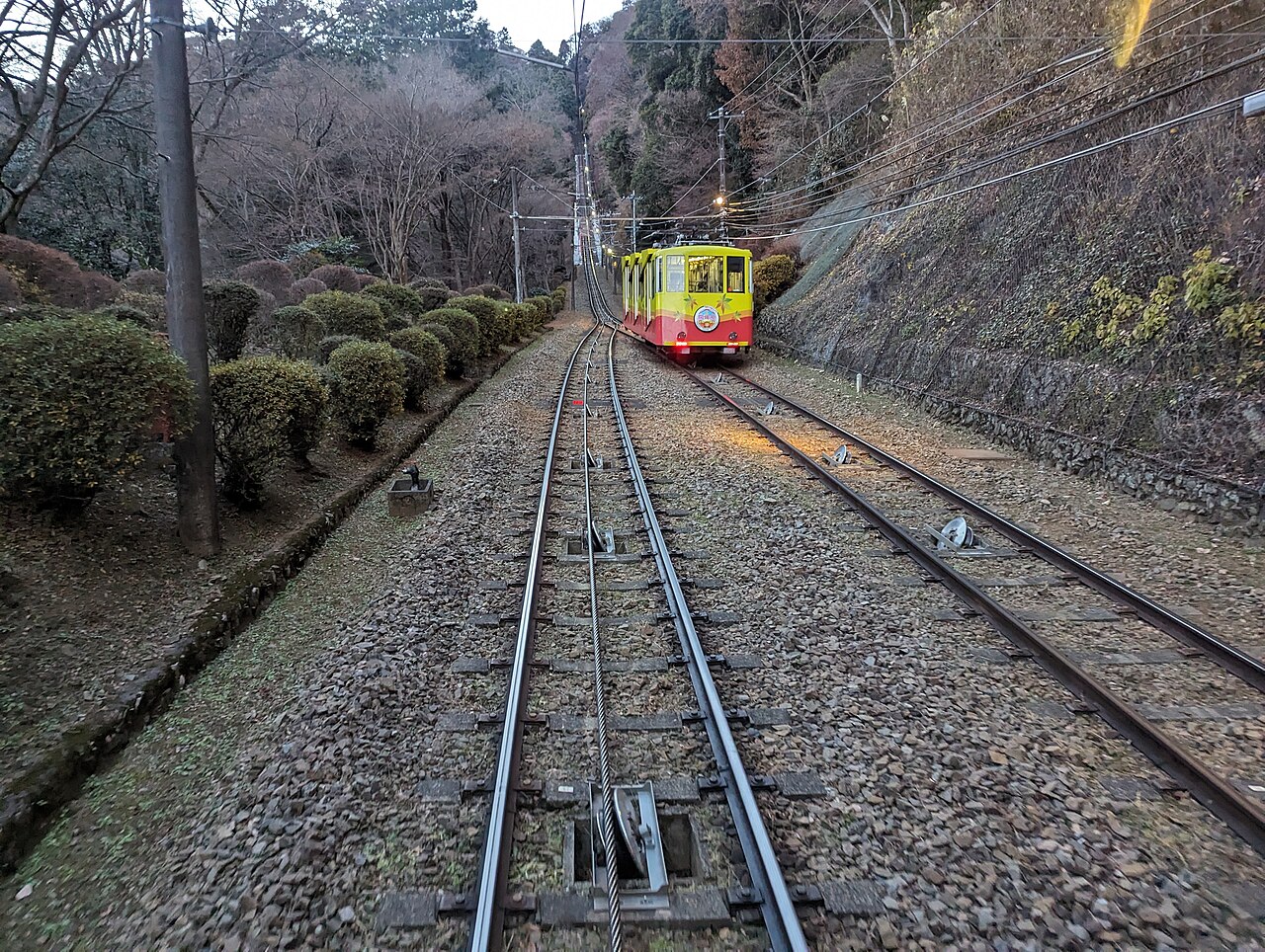 A Takao cable car climbing the steep track up the mountainside.